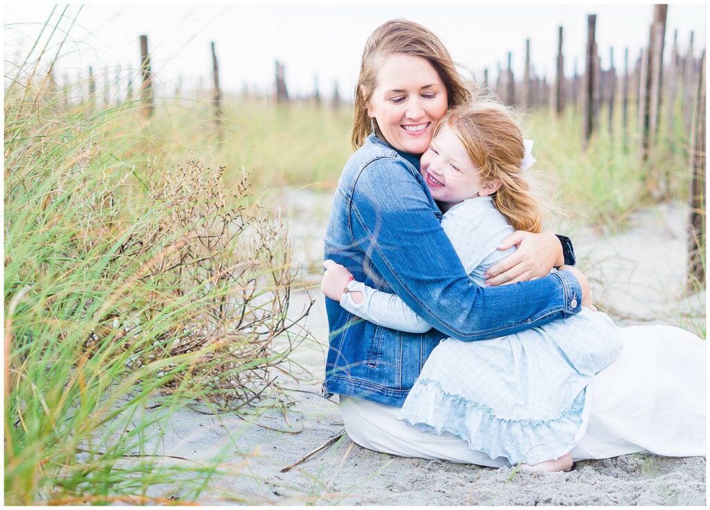 mom hugging daughter on the beach