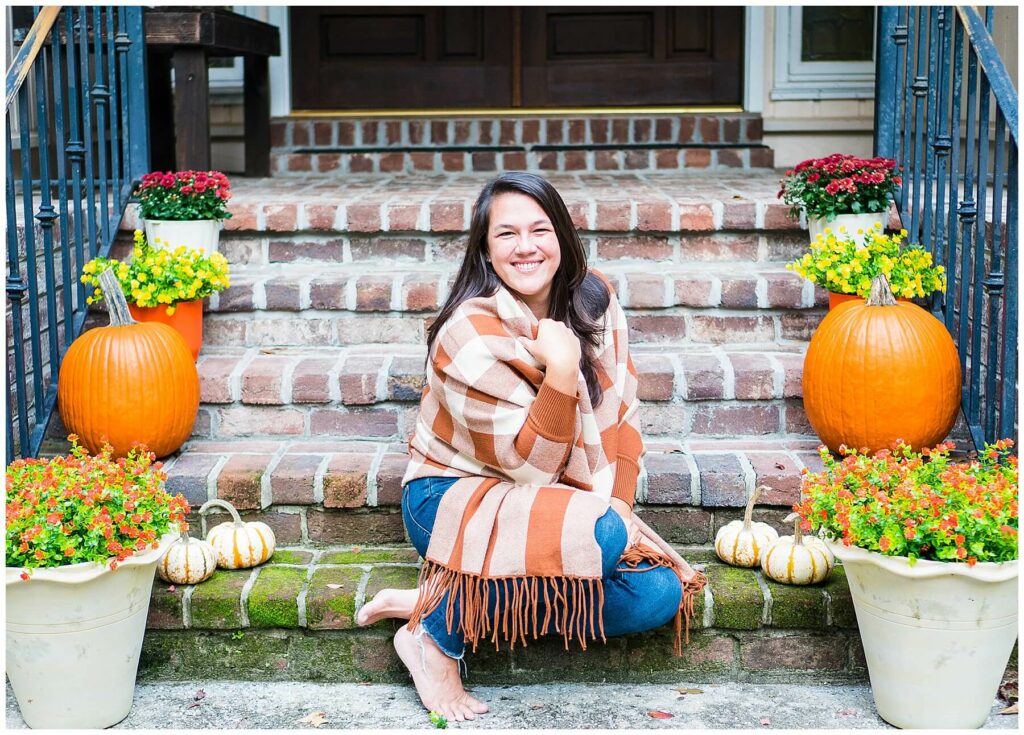 woman on stairs with pumpkins in fall wrap