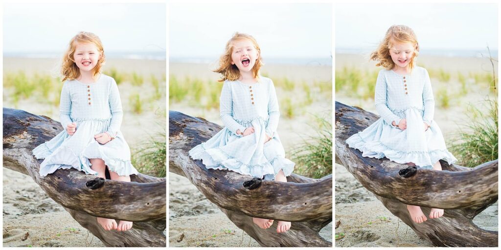 little girl in blue dress sitting on driftwood