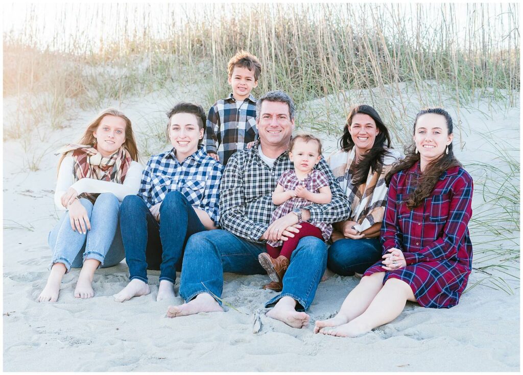 family of 7 sitting on a beach