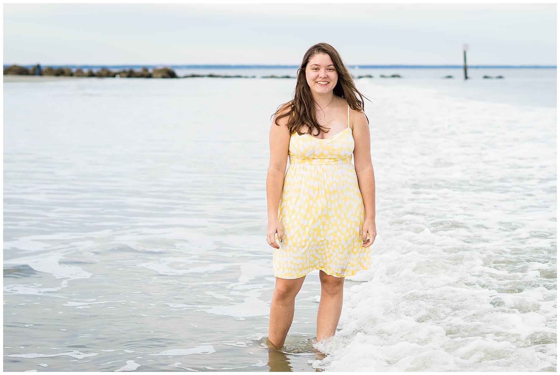 girl in yellow dress in water at beach