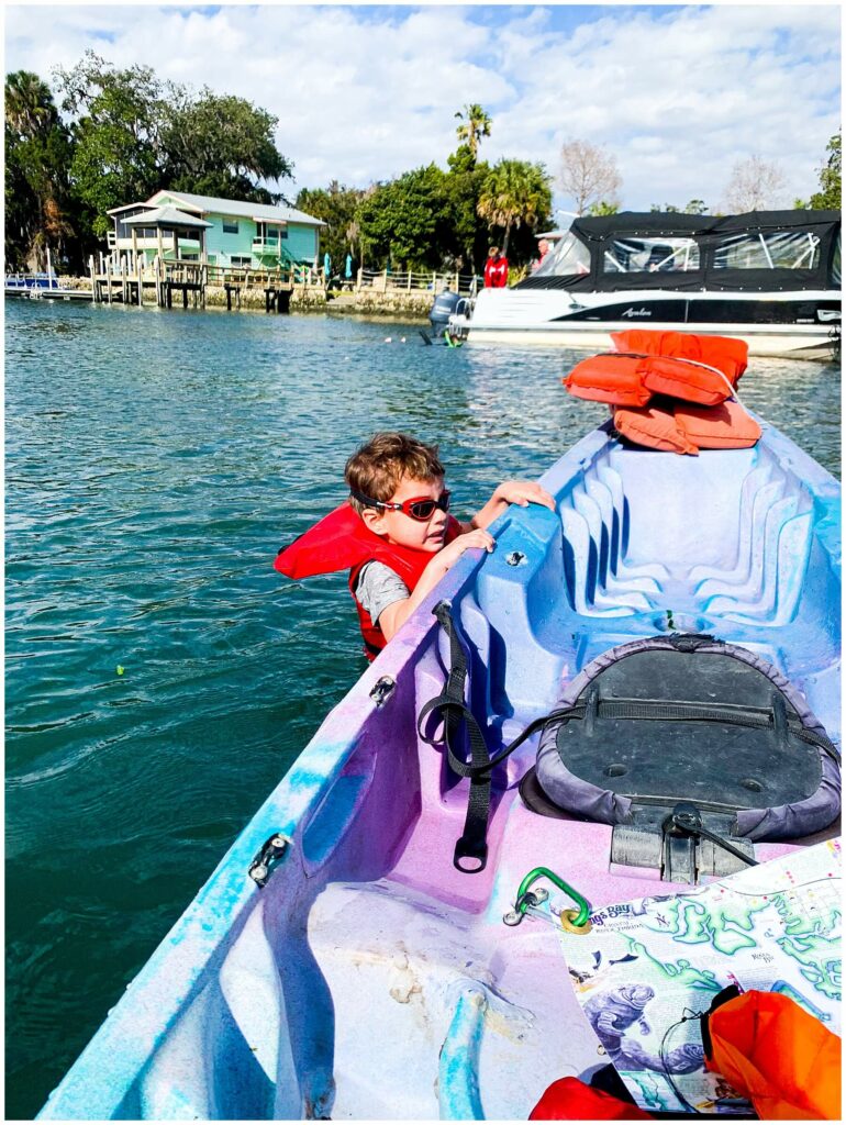 little boy clinging to kayak