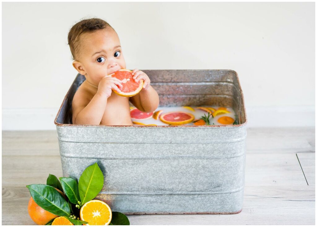little boy in tub of fruit