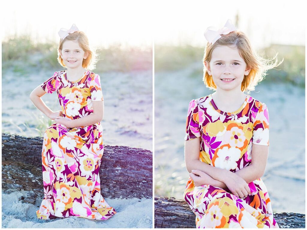 little girl in bright dress sitting on driftwood
