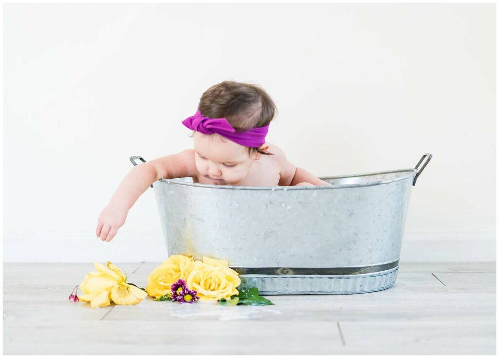 baby girl in milk bath with yellow roses