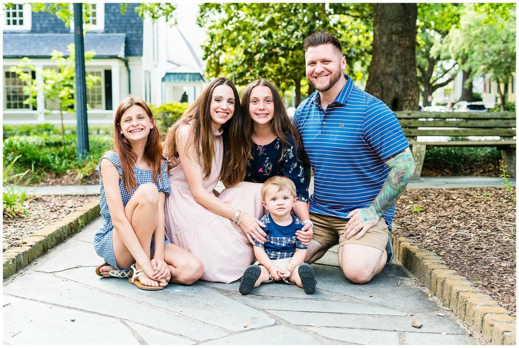 family of 5 equating around a toddler for a family photo in downtown savannah Georgia 