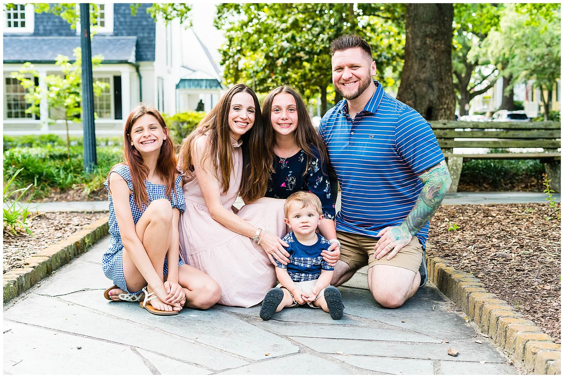 family of 5 equating around a toddler for a family photo in downtown savannah Georgia