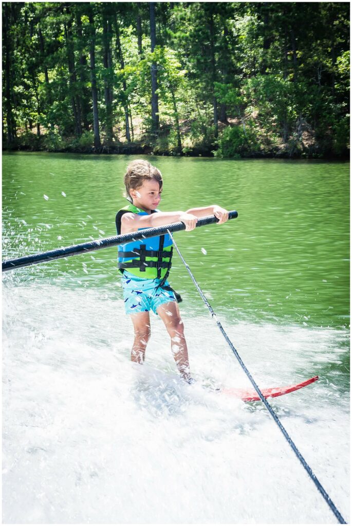 little boy water skiing on one ski