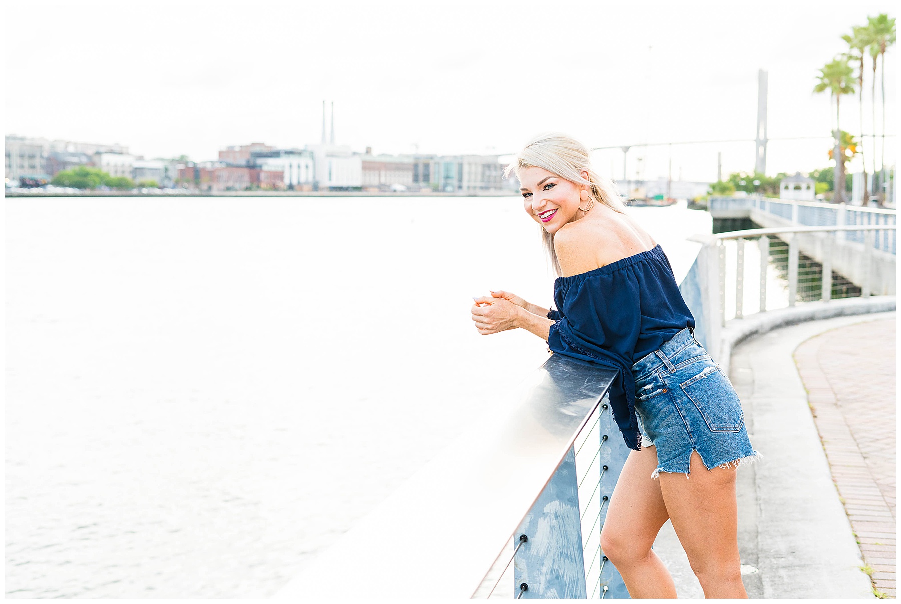 woman leaning on rail overlooking Savannah river and Downtown Savannah Georgia