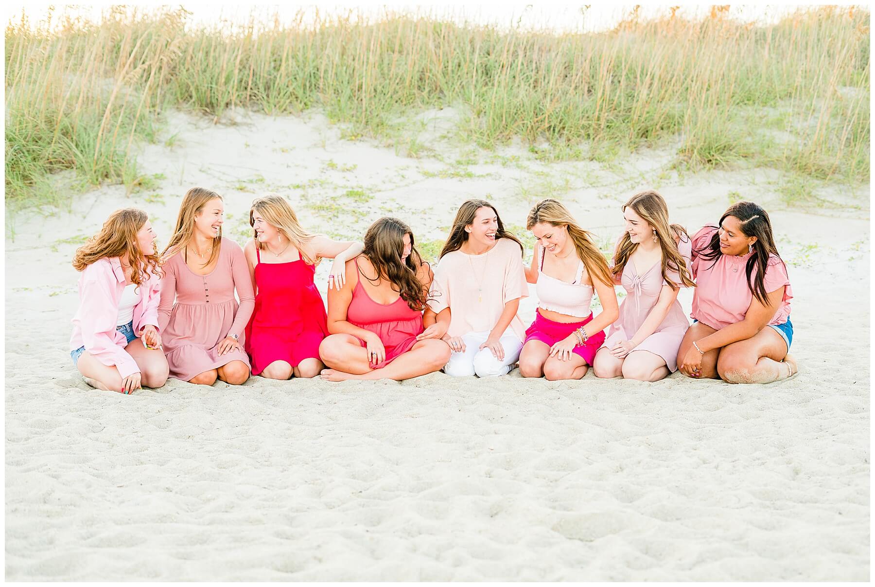 high school senior girls wearing pink at the beach for senior pictures