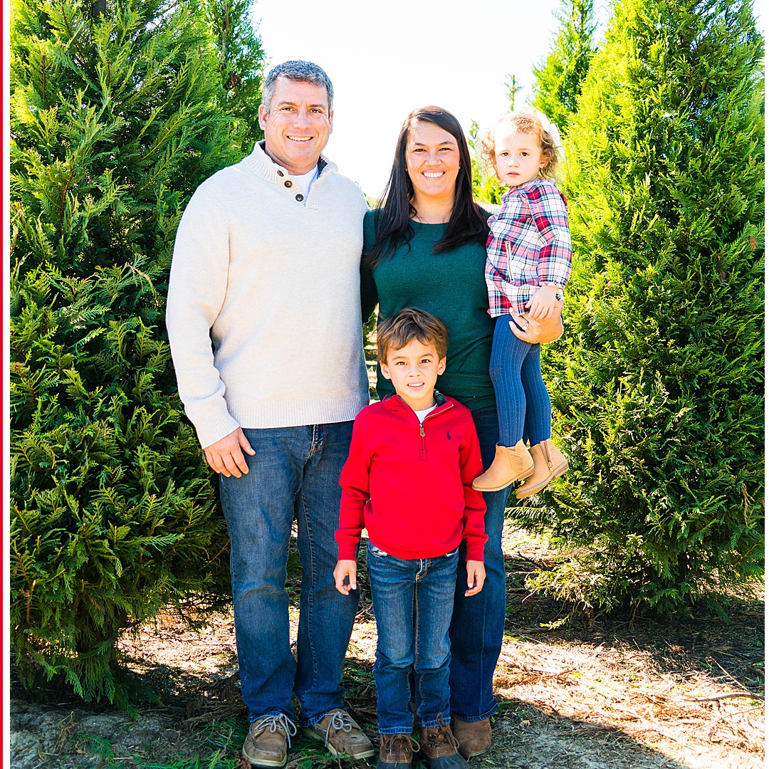 family of four at a Christmas tree farm near Savannah Georgia smiling at the camera
