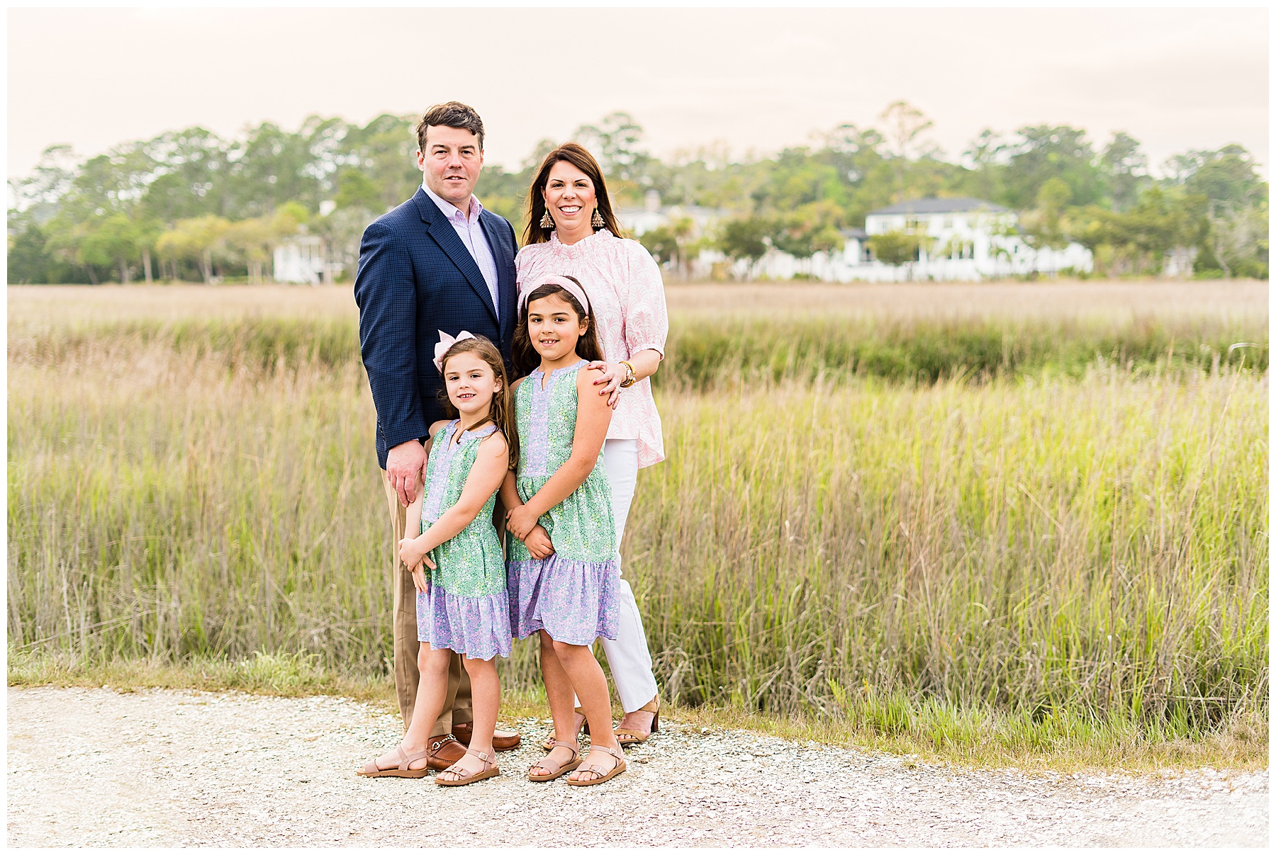 family of four standing in front of the marsh on Skidaway Island for a family photo