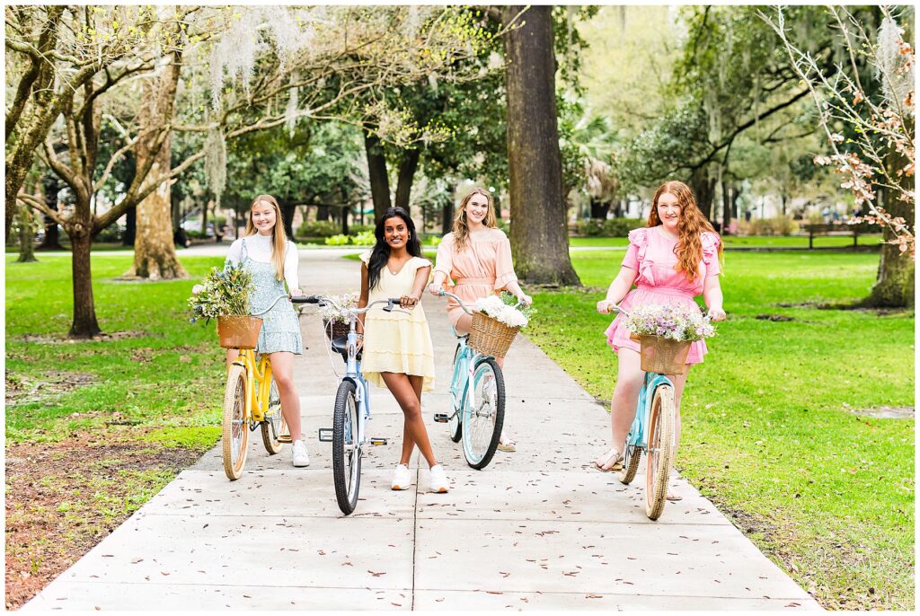 group of high school senior girls standing with bikes in Forsyth Park