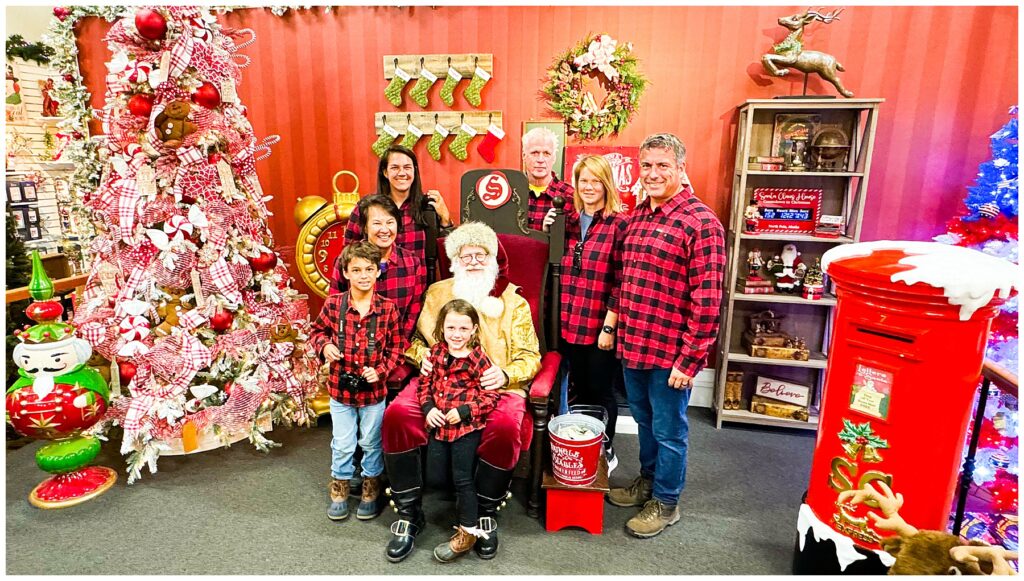 family in matching plaid shirts with Santa in North Pole Alaska