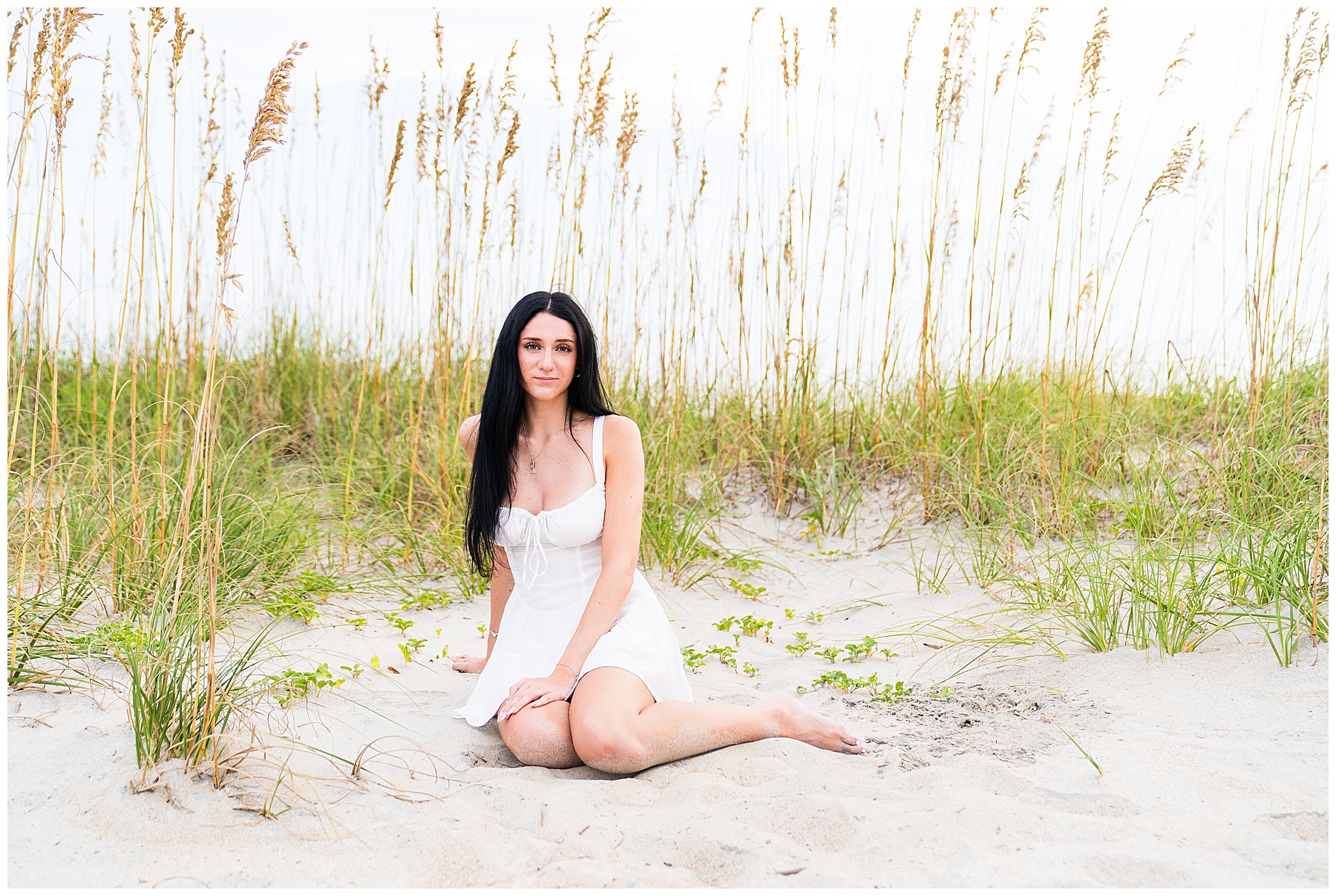 photo of a high school senior girl wearing a white dress on Tybee Island at sunset