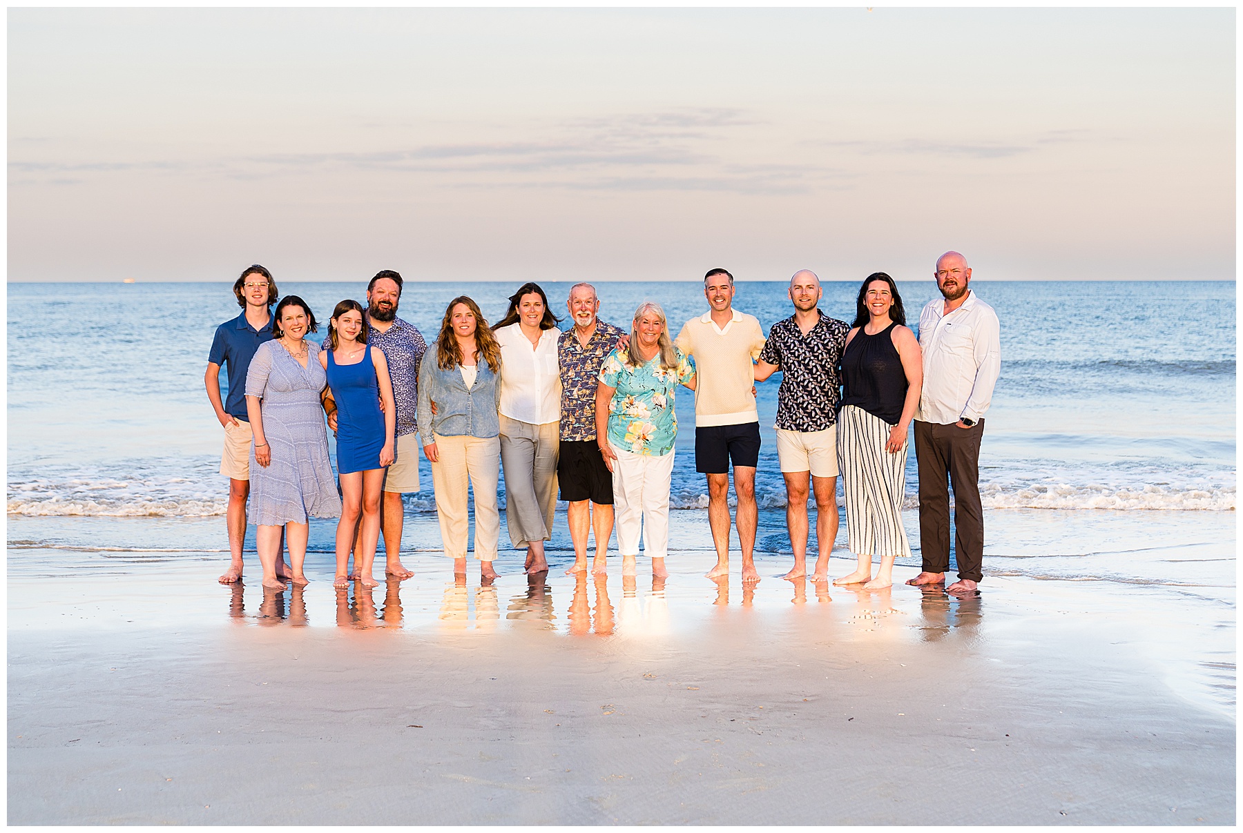 extended family standing in the surf on Tybee Island for family photos at sunset