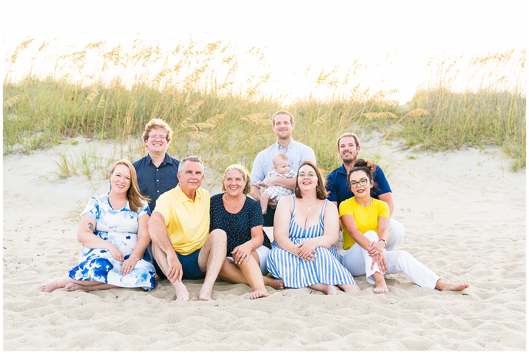 family sitting on the beach with the dunes in the background at sunset on Tybee Island