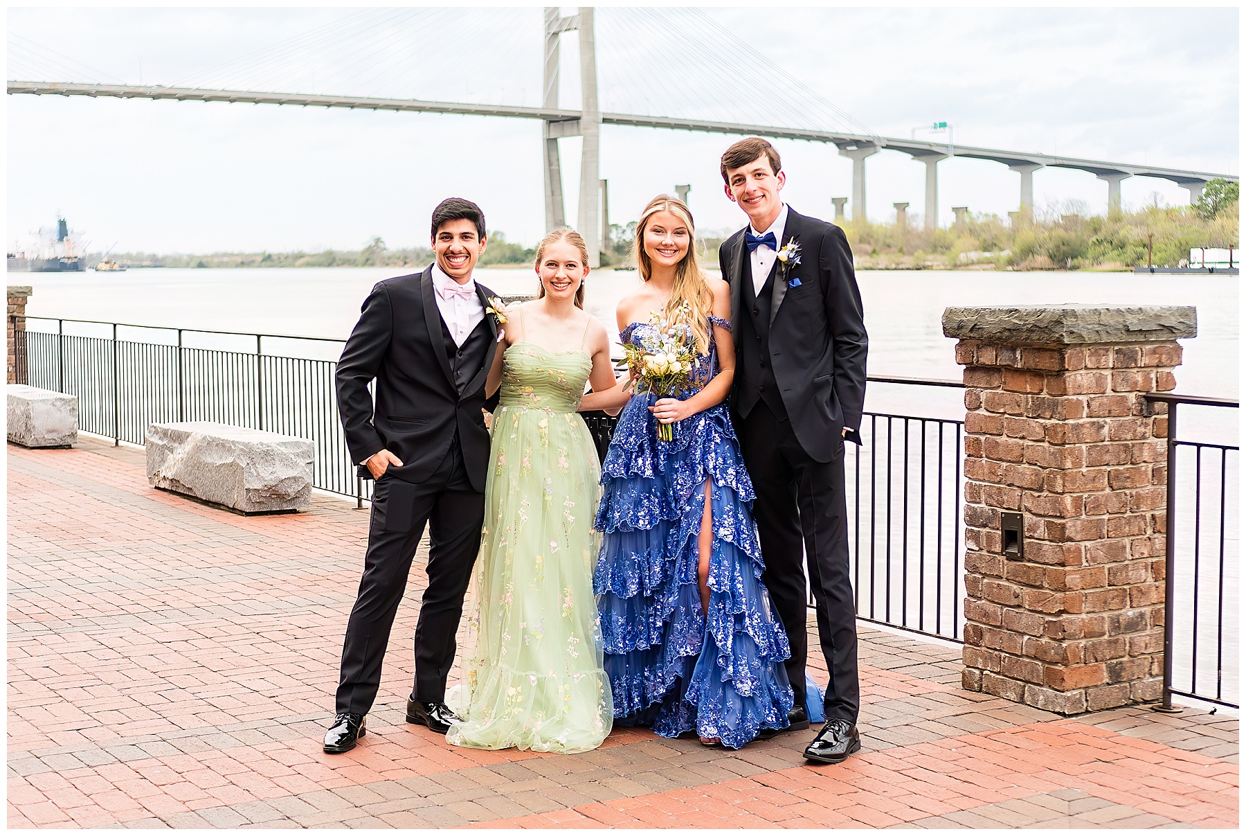 photo of four high schoolers posing for prom photos on Savannah's River Street walk