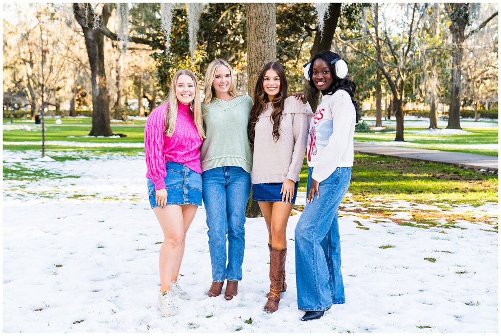 photo of four high school senior girls standing in the snow in Savannah's Forsyth Park