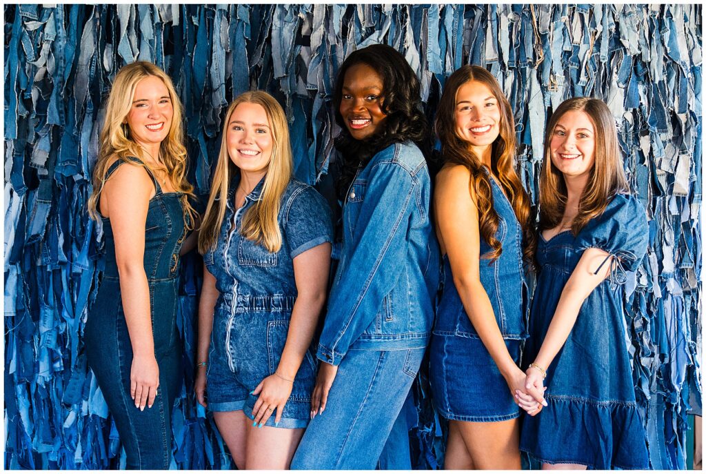 photo of high school senior girls dressed all in denim standing in front of a denim fringe backdrop