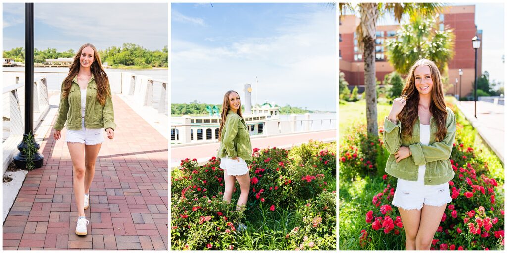 This collage features a high school senior enjoying a sunny day in Savannah, styled in a fresh, casual look perfect for spring or summer photos. She’s wearing a light green corduroy jacket over a white top, paired with white distressed shorts and white sneakers with a gum sole. Her long, wavy auburn hair is styled down, and she has a confident, relaxed smile in each shot. Left Image: She walks confidently toward the camera on a brick-paved riverside walkway, framed by a tall black lamppost. The setting and her stride give the image movement and a modern, carefree vibe. Middle Image: She’s standing in front of a paddlewheel riverboat and lush red roses, looking over her shoulder with her hands in her pockets. The setting feels iconic and romantic with a touch of whimsy. Right Image: She stands beside palm trees and bright pink flowers in a sunny landscaped area, smiling softly with one hand playing in her hair. The blurred buildings in the background give a hint of city life while keeping her as the main focus. Overall, the series feels vibrant, youthful, and full of personality—capturing both confidence and charm in a coastal Southern setting.