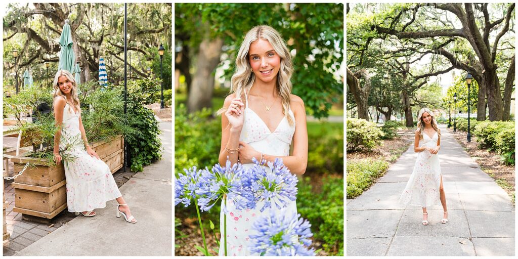 This is a beautiful, light-filled senior photo collage featuring three images of a blonde high school senior in a flowy white sundress with a soft pastel floral pattern. Here's a breakdown of each image:

Left Image:
The senior is sitting casually on the edge of a large wooden planter in what appears to be a café patio or park setting. The background includes umbrellas, string lights, and draping Spanish moss from large oak trees, giving a charming, southern vibe. Her white block heels add a polished touch to the relaxed, summery look.
Center Image:
A close-up portrait with a soft smile. She's surrounded by greenery and delicate lavender-blue agapanthus flowers in the foreground, adding dimension and a romantic botanical feel. She wears a dainty gold necklace with a “W” pendant and subtle bracelets, keeping accessories youthful and sweet.
Right Image:
A full-body shot on a paved path lined with lush bushes and large oak trees overhead, their branches creating a natural canopy. Her dress flows gently in the breeze, and she looks effortlessly graceful, standing in the center of the walkway with a soft, confident pose.