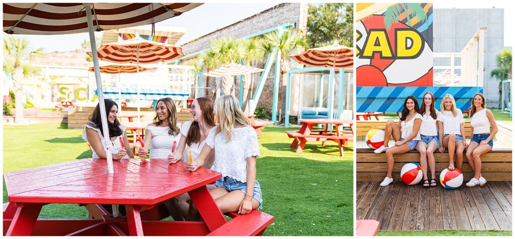The image is a bright, summery collage of two photos featuring four young women enjoying a fun outdoor setting. Left photo: The group is sitting at a red picnic table under a striped umbrella, holding colorful popsicles and laughing together. The background has palm trees, red picnic tables, and playful cabana-style seating, giving off a relaxed, beachy vibe. Right photo: The same four women are sitting on a wooden ledge in front of a colorful mural that includes the word “RAD” and a beach ball design. They’re casually dressed in white tops and denim shorts, with beach balls on the ground adding to the summery atmosphere. The overall mood is cheerful and carefree, with strong summer and beach party vibes.